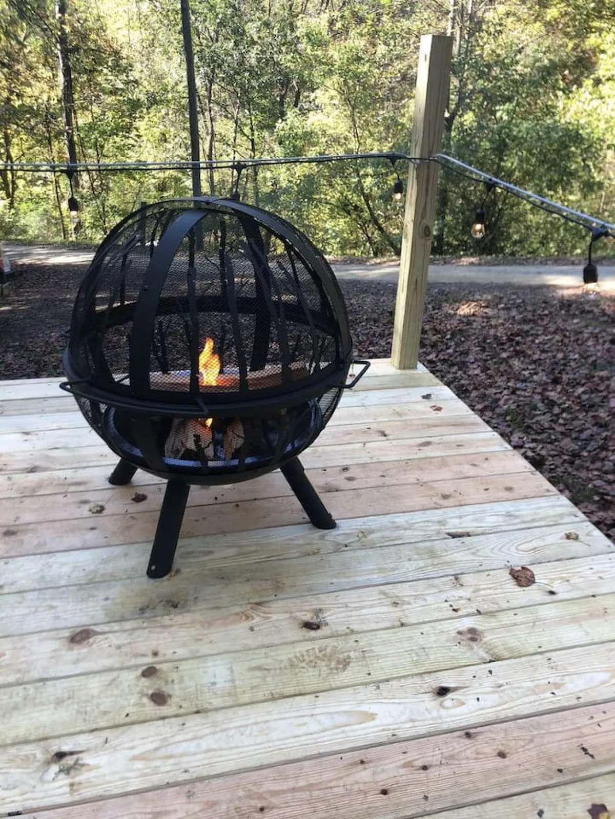 A cozy outdoor fire pit encircled by comfortable seating on a wooden deck, bordered by lush greenery. The warm glow of the fire invites couples to gather, roast marshmallows, or share stories under the stars, creating memorable evenings together.